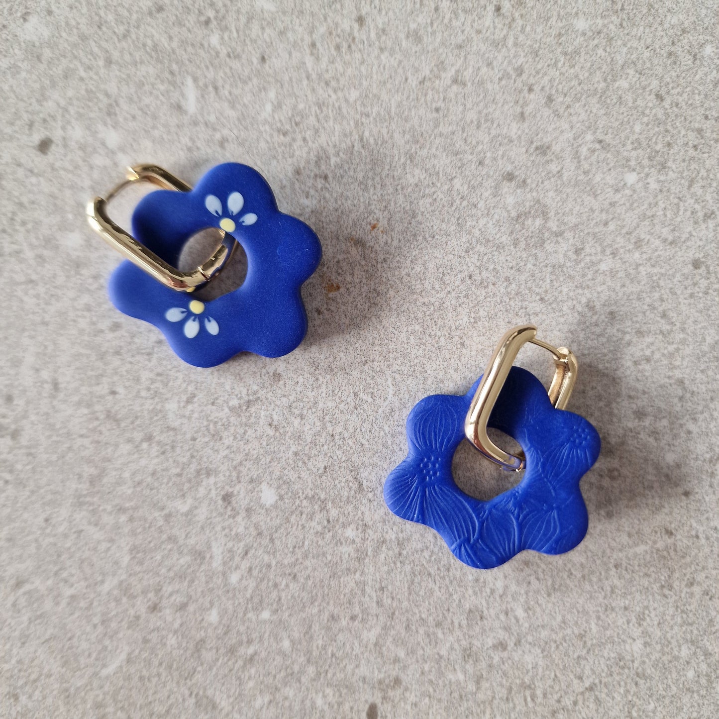 Silia Ohrringe in Blau, asymmetrisch handbemalt und gefräst, getragen an 18K-beschichteten goldenen Creolen, handgemacht in Düsseldorf