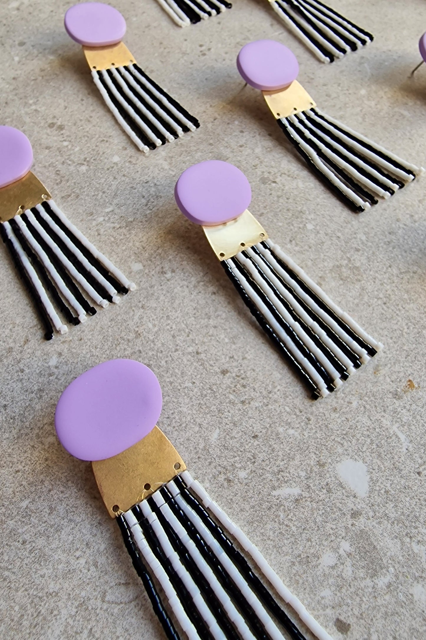 Detailansicht: Polymer Clay Ohrringe mit Fransen, Perlen und Messingelement – Noir & Neve