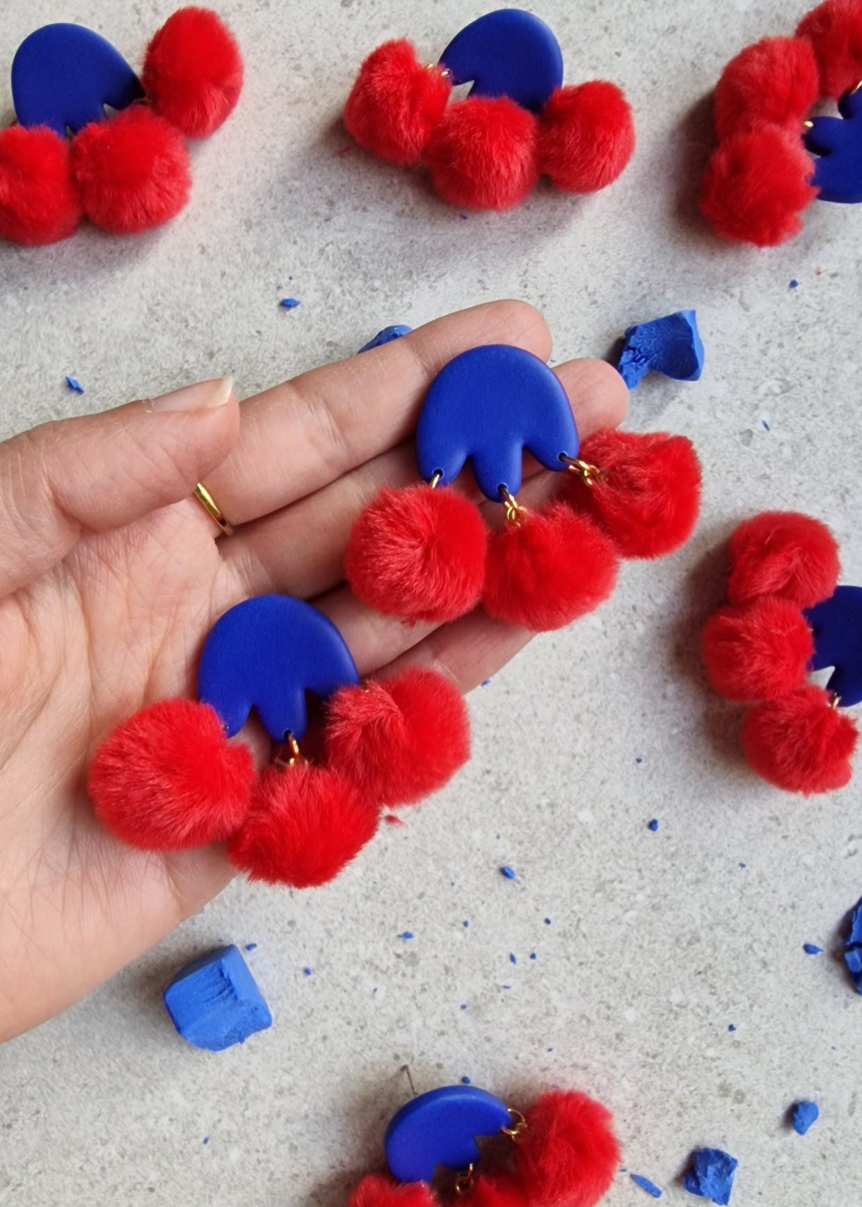 Sommerliche Statement-Ohrringe am Ohr – handmade aus Polymer Clay und Pompons