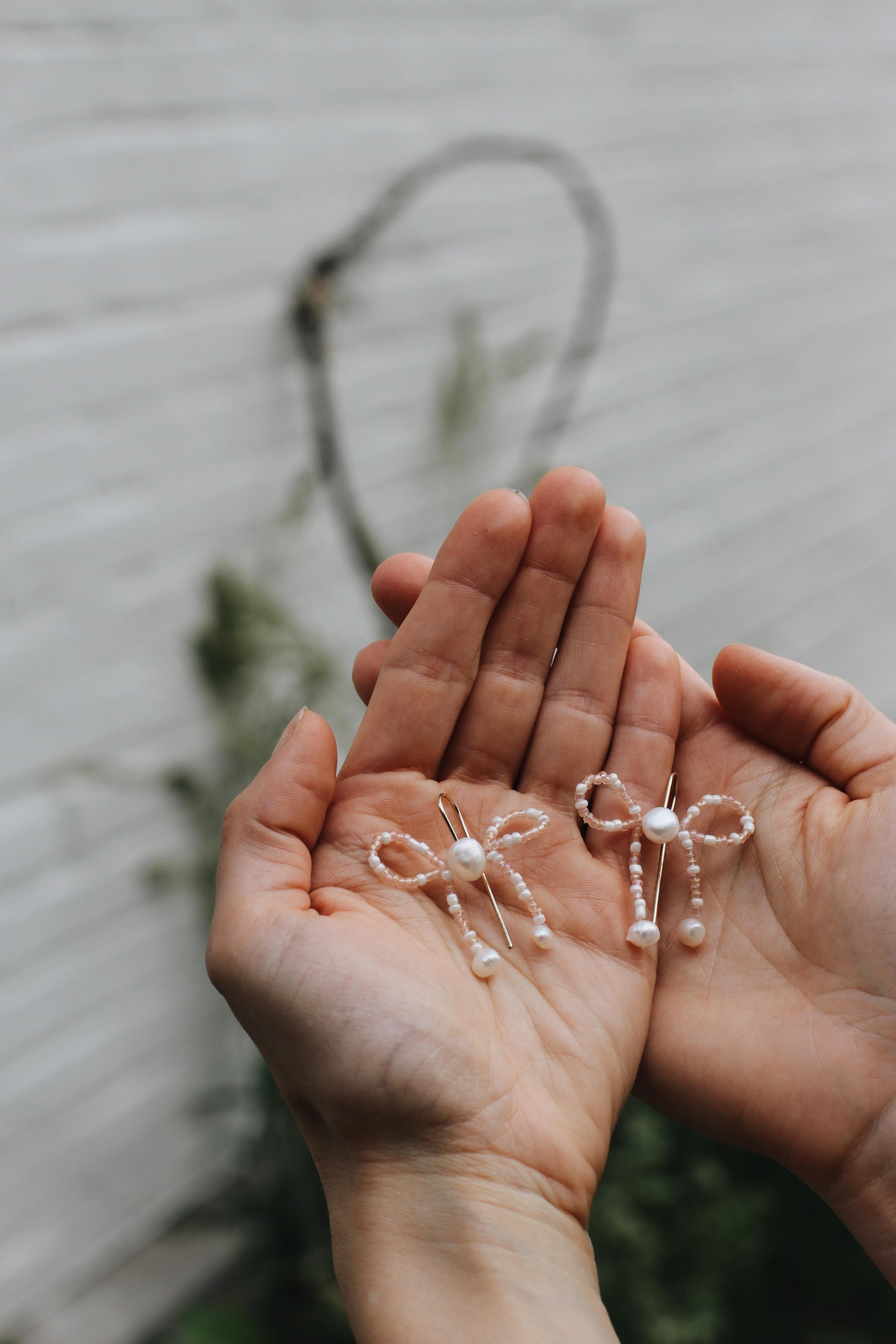 Detailaufnahme von Schleifenohrringen mit Mini-Süßwasserperlen – eleganter Vintage Boho Look.